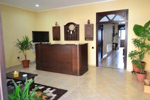 a lobby with a reception desk and a clock on the wall at Porto Franco Residence in Brăila