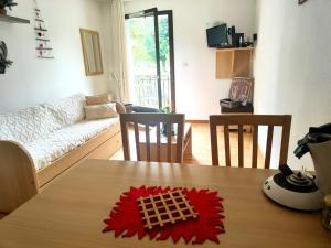 a living room with a table with a red flower on it at Chez Soso in Luchon