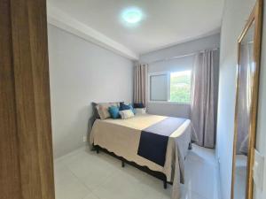 un dormitorio con una cama y una ventana en Charmoso com varanda - Ar condicionado - 1 Vaga, en Santos