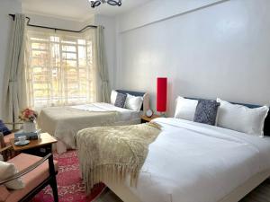 a bedroom with two beds and a window at Casa Bellà Game View in Nakuru