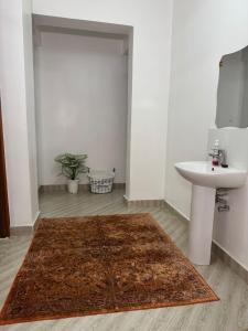 a bathroom with a sink and a rug on the floor at Casa Bellà Game View in Nakuru +55 photos