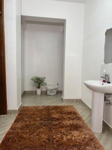 a bathroom with a sink and a rug on the floor at Casa Bellà Game View in Nakuru