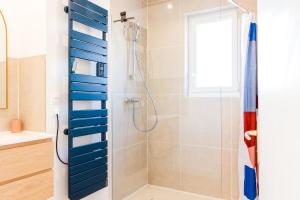 a bathroom with a shower with blue dividers at L'escapade colorée - gare - Futuroscope - parking in Poitiers +20 photos