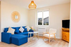a living room with a blue couch and a table at L'escapade colorée - gare - Futuroscope - parking in Poitiers
