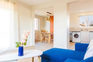 a living room with a blue couch and a table at L'escapade colorée - gare - Futuroscope - parking in Poitiers