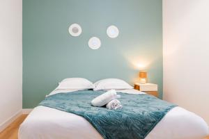 a bedroom with a large bed with towels on it at L'escapade colorée - gare - Futuroscope - parking in Poitiers
