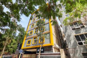 a yellow building with windows on a street at Super Hotel O New Cyber Grand Madhapur in Hyderabad