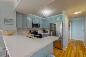 a kitchen with blue cabinets and a white counter top at Island Beach & Racquet Club G210 in Atlantic Beach