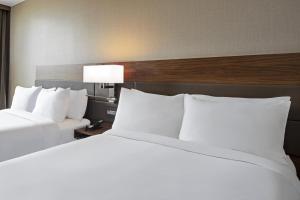 two beds in a hotel room with white pillows at AC Hotel by Marriott St. Louis Clayton in Clayton +47 photos