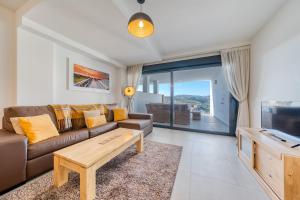 a living room with a couch and a tv at Blue Sunset Retreat in Manilva