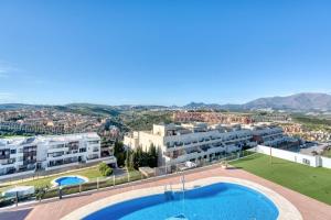 an apartment with a swimming pool and a building at Blue Sunset Retreat in Manilva