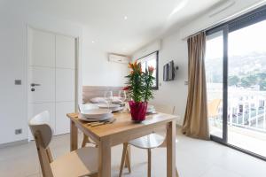 a dining room with a table and chairs and a window at Palais Saint Pierre in Cagnes-sur-Mer