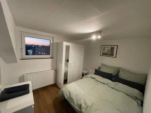 a small bedroom with a bed and a window at Alios Duren in Düren - Eifel