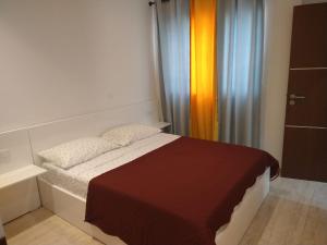 a small bedroom with a bed and a curtain at Ladeira apartamentos in Ribeira Grande