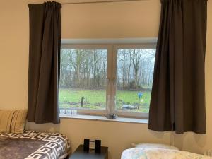 a bedroom with a window with a view of a field at Højmosegård værelse 1 in Varde