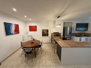 a kitchen and dining room with a table and a counter at Appartement moderne avec jardin, quartier calme in Saint-Claude