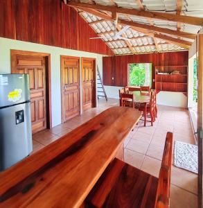 a kitchen and dining room with a large wooden table at Corcovado Green Cabin & House in Drake