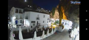 a group of buildings with umbrellas next to a mountain at La Medina Alta in Setenil +7 photos