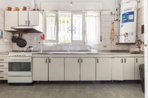 a kitchen with white cabinets and a sink at Casa García MDZ in Mendoza