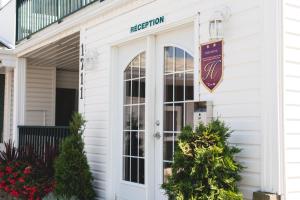 een voordeur van een wit huis met een bord erop bij Motel Park in Val-dʼOr