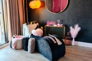 Cette chambre comprend une chaise et un miroir. dans l'établissement 50 Shades Of Grey - Romance Suite! Couples Retreat 717, à Myrtle Beach