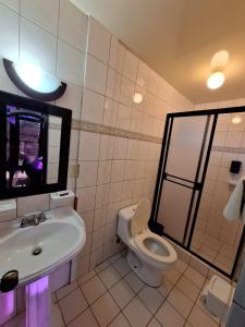 a bathroom with a sink and a toilet and a mirror at Motel Jabaloyas in Tijuana +14 photos