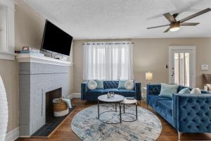 a living room with a blue couch and a fireplace at Forest Park Oasis by JZ Vacation Rentals in Tower Grove