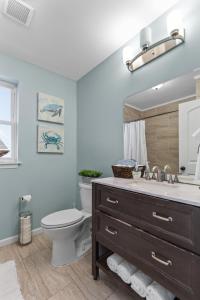 a bathroom with a sink and a toilet and a mirror at Forest Park Oasis by JZ Vacation Rentals in Tower Grove +29 photos