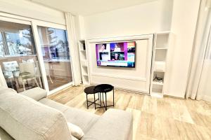 salon z kanapą i telewizorem na ścianie w obiekcie MARBELLA ALICATE BEACHFRONT - Luxury Apartment-2 w Marbelli