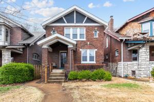 a brick house with a porch and a driveway at Forest Park Oasis by JZ Vacation Rentals in Tower Grove