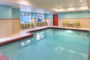 a pool in a hotel room with chairs and tables at SpringHill Suites by Marriott Atlanta Six Flags in Lithia Springs