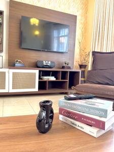 a living room with books and a tv on a wall at Casa Bellà section 58 in Nakuru
