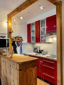 une cuisine avec des armoires rouges et un comptoir dans l'établissement Vue mer, balcon, 50m plage & village, au calme - centre ville historique, 2P pour 4 maximum, à Villers-sur-Mer