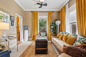 a living room with yellow curtains and a couch at Old Carrabelle Hotel Flamingo Suite in Carrabelle