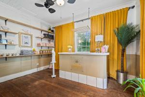 a room with yellow curtains and a counter and a plant at Old Carrabelle Hotel Flamingo Suite in Carrabelle +12 photos