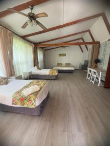 a bedroom with two beds and a ceiling fan at Hotel Hotu Matua by EI in Hanga Roa