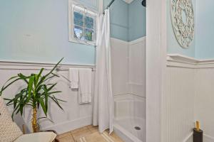a bathroom with a shower and a potted plant at Old Carrabelle Hotel Captains Quarters Suite in Carrabelle