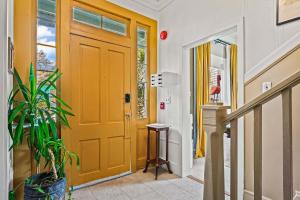 a orange door in a hallway with a plant at Old Carrabelle Hotel Captains Quarters Suite in Carrabelle