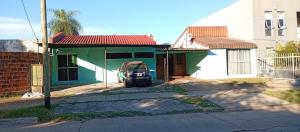 a green house with a car parked in front of it at Ultra in Ituzaingó