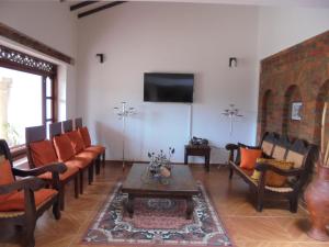 een woonkamer met banken en een flatscreen-tv bij Hospederia Villa Berenita in Villa de Leyva