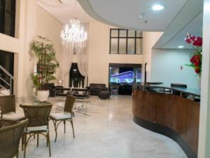 a lobby with a chandelier and tables and chairs at The Palace Flat Moema 1210 in São Paulo