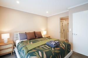 a bedroom with a large bed with a green blanket at Stylish City Pad Luxe, Comfy, Central in Dunedin