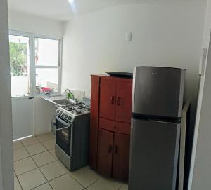 a small kitchen with a stove and a refrigerator at Depto cerca de Tequesquitengo in Tlatenchu