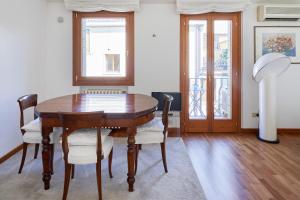 Casa Ambra la tranquillità in centro città في بادوفا: غرفة طعام مع طاولة وكراسي خشبية
