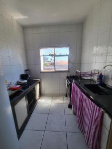 a small kitchen with a sink and a window at Casa da Felicidade in Rio das Ostras