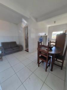 a living room with a table and chairs and a couch at Casa da Felicidade in Rio das Ostras +8 photos