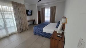 a hotel room with a bed and a television at Casablanca Resort  in Rincon de Guayabitos +22 photos