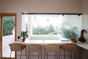 a kitchen with a table with chairs and a window at Casa Miztli in Brisas de Zicatela