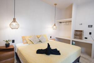a bedroom with a bed with a black robe on it at Casa Miztli in Brisas de Zicatela