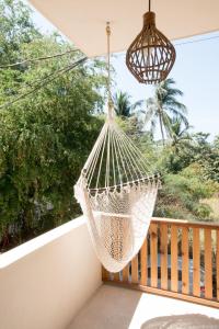 a hammock hanging on a balcony with a window at Casa Miztli in Brisas de Zicatela